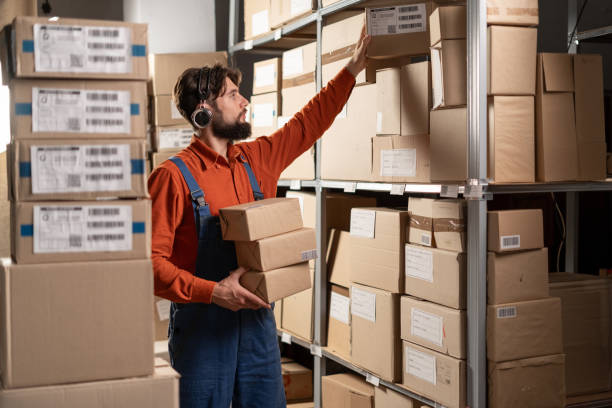 Male warehouse worker take box from shelf in big warehouse factory, Online shopping store for logistic service to deliver the shipment. Copy space