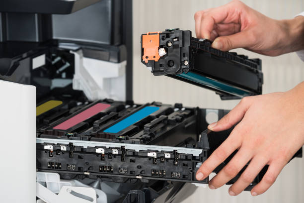 Midsection of young businessman fixing cartridge in printer machine at office